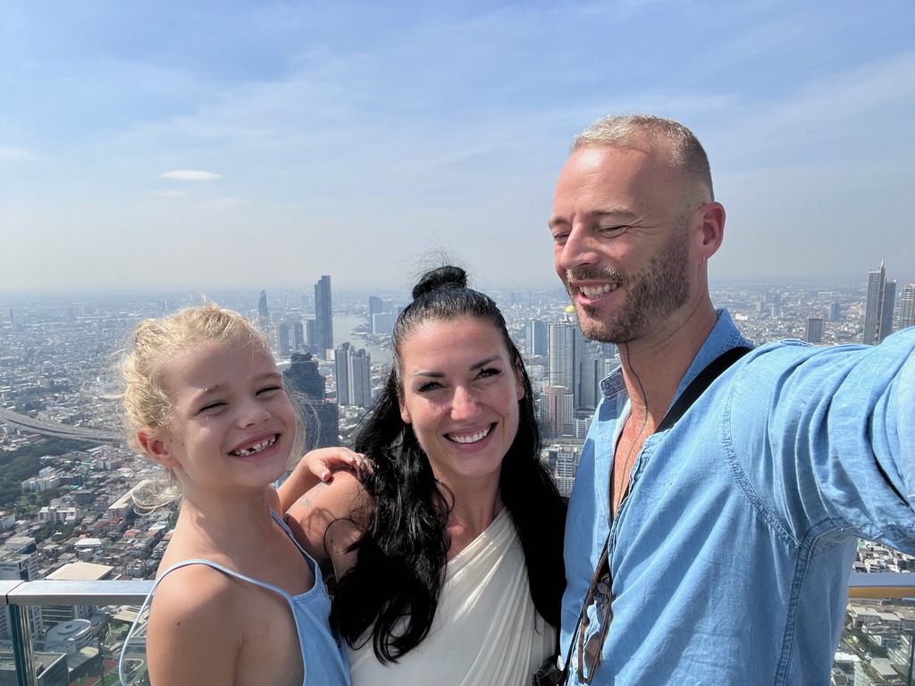 Family with young daughter standing on top of a building in Bangkok