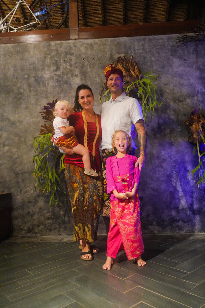 Family of four wearing traditional balinese costumes