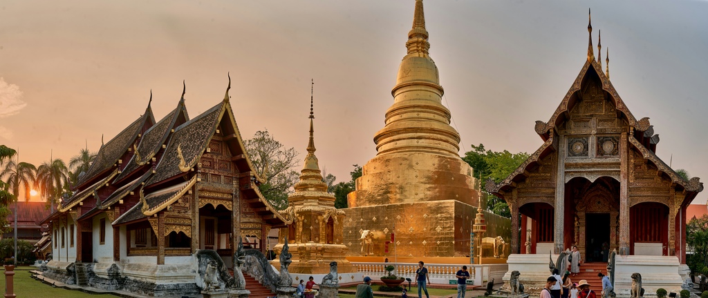 Wat Phra Singh Temple in Chiang Mai, Thailand, with its traditional ornate buildings and a golden stupa, illuminated by the soft glow of the setting sun, Thailand family itinerary