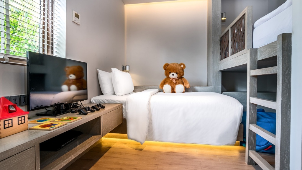 Hotel room for kids with giant stuffed toys sitting on the beds