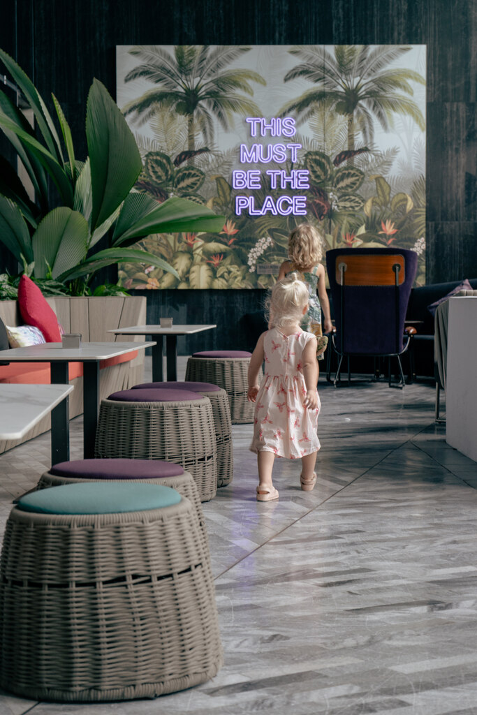 Two young girls running through a stylish hotel lounge