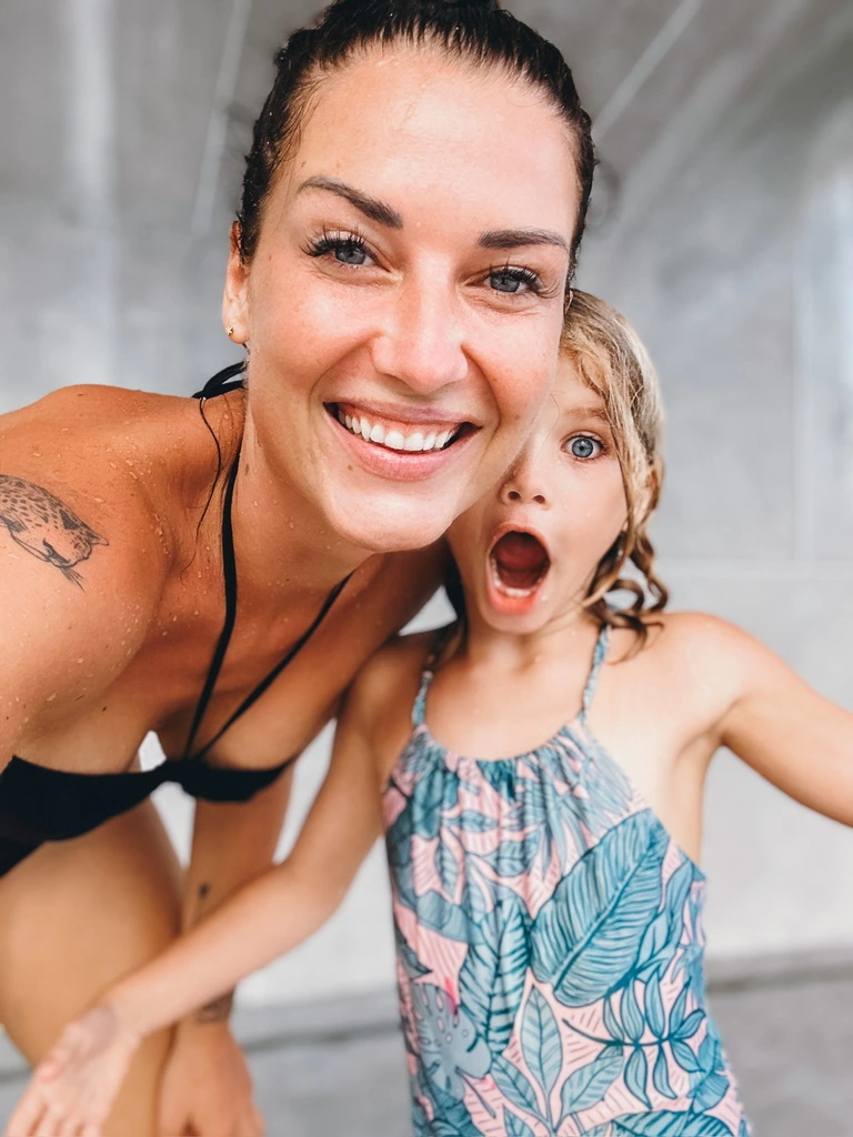 Mum and daughter in swimwear laughing into the camera at Hyatt Samui