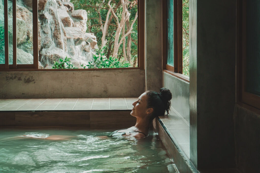 Woman sitting in Onsen Pool with closed eyes