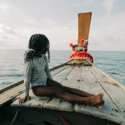 Girl sitting on a longtail boat in Thailand, How to Get From Phuket to Krabi? The 4 Easiest Ways