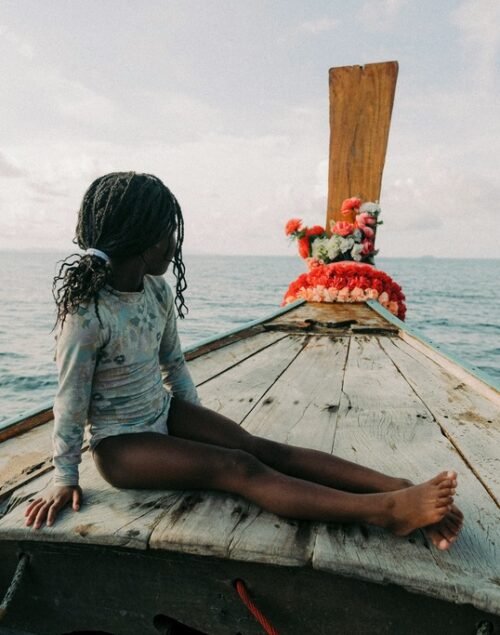 Girl sitting on a longtail boat in Thailand, How to Get From Phuket to Krabi? The 4 Easiest Ways