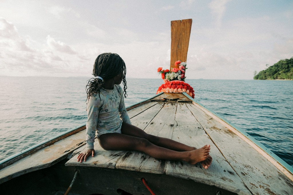 Girl sitting on a longtail boat in Thailand, How to Get From Phuket to Krabi? The 4 Easiest Ways