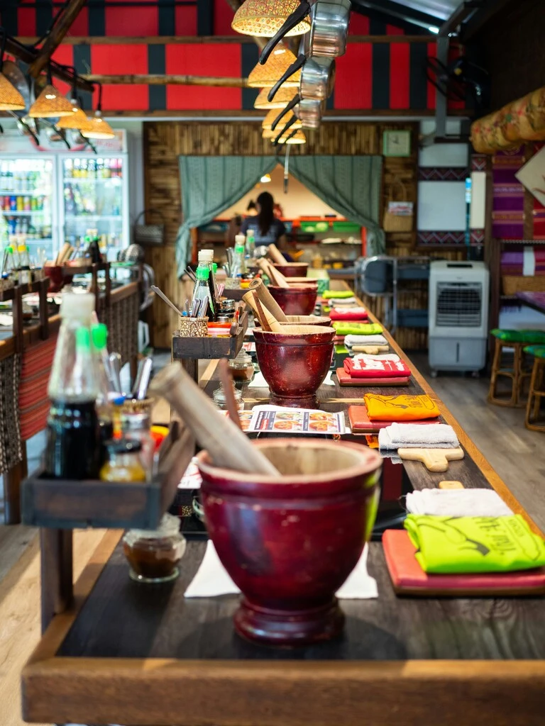 Table with cooking gear lined up, prepared to start a thai cooking workshop