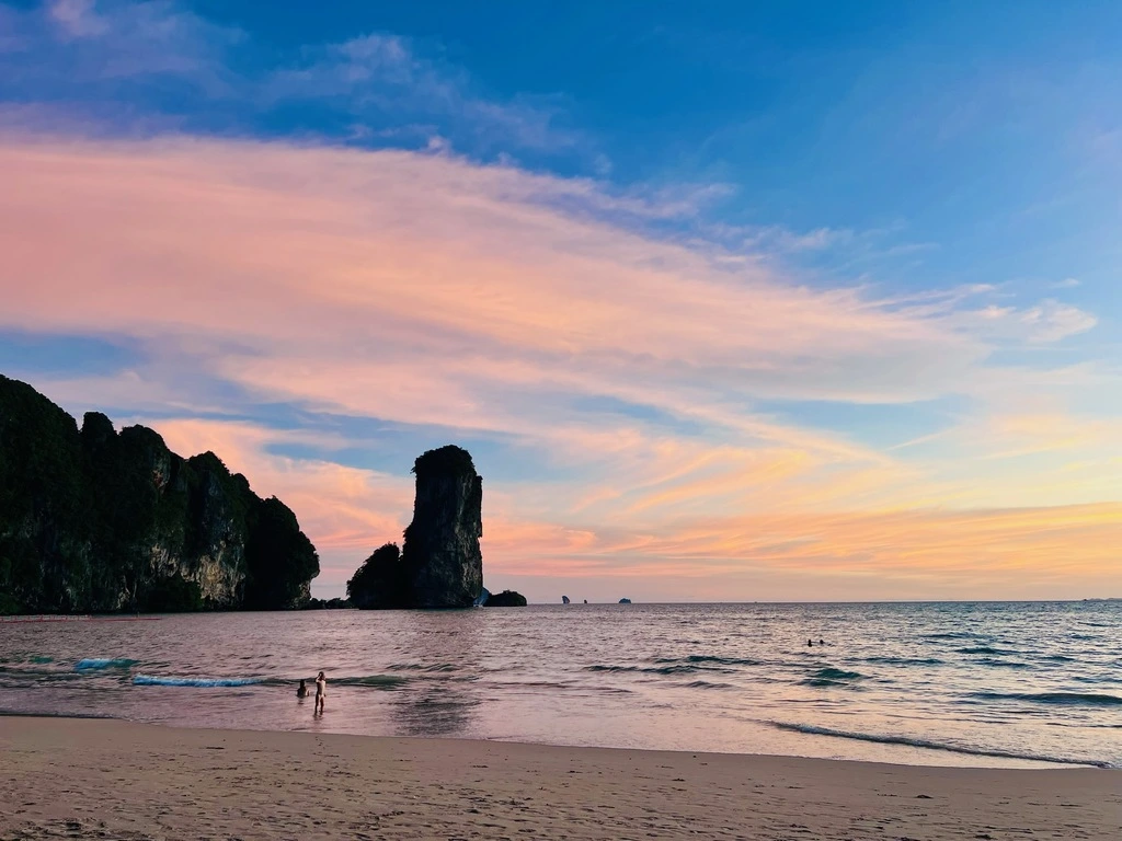 Sunset at beach with cliffs in the background.