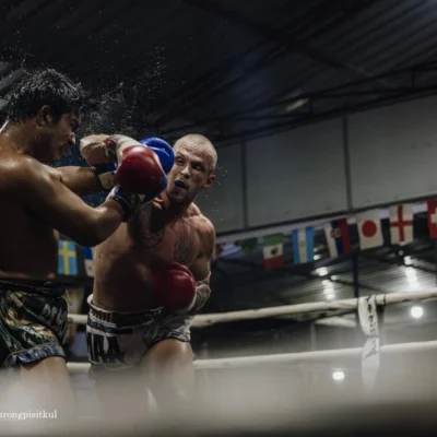 Two Muay Thai fighters fighting each other in the ring.