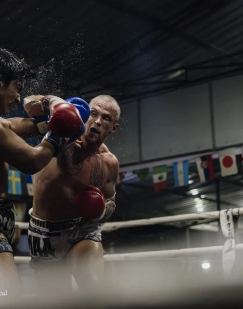 Two Muay Thai fighters fighting each other in the ring.