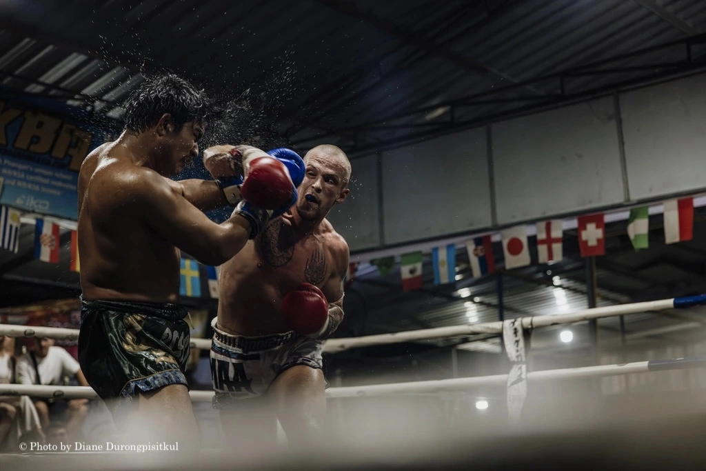 Two Muay Thai fighters fighting each other in the ring.