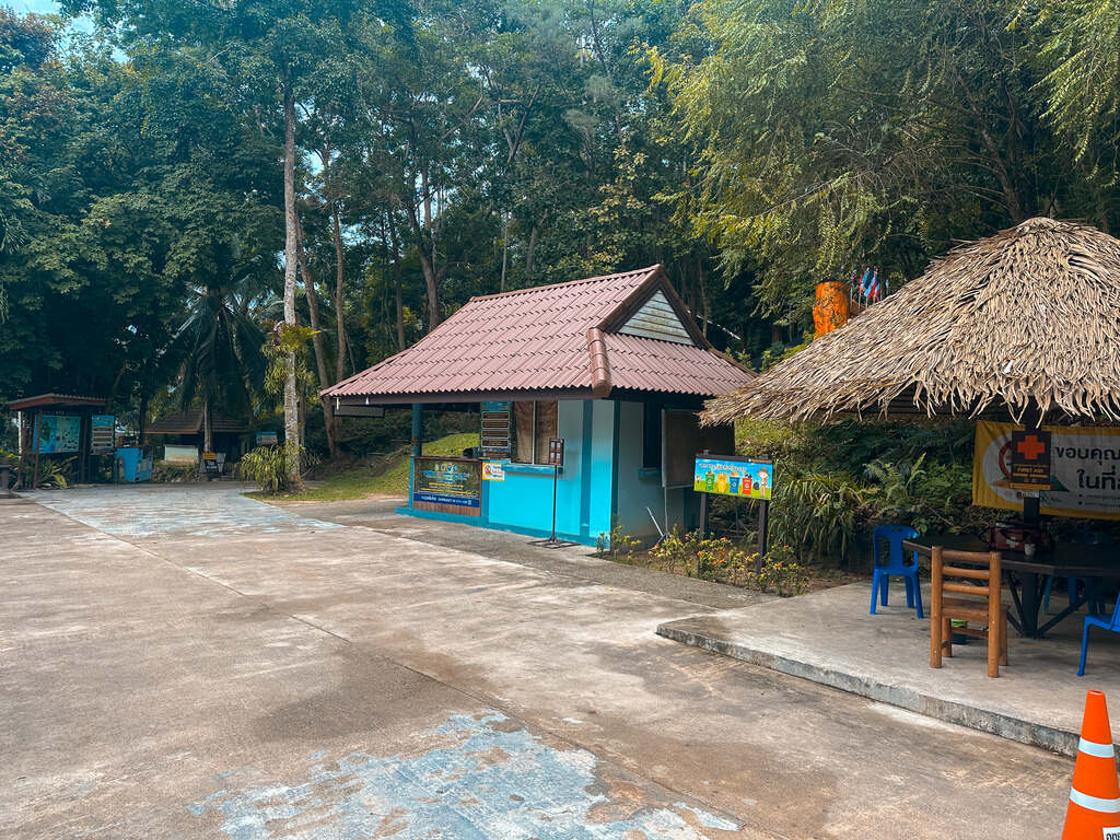 Small blue ticket office on parking lot, Phaeng Waterfall hike