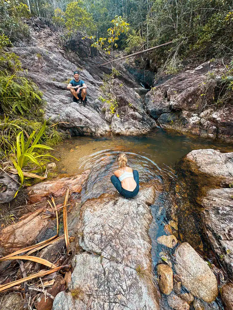 Father and daughter enjoying a waterfall pool.