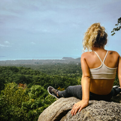 Girl sitting on a rock enjoying the views on the Phaeng Waterfall Hike in Koh Phangan