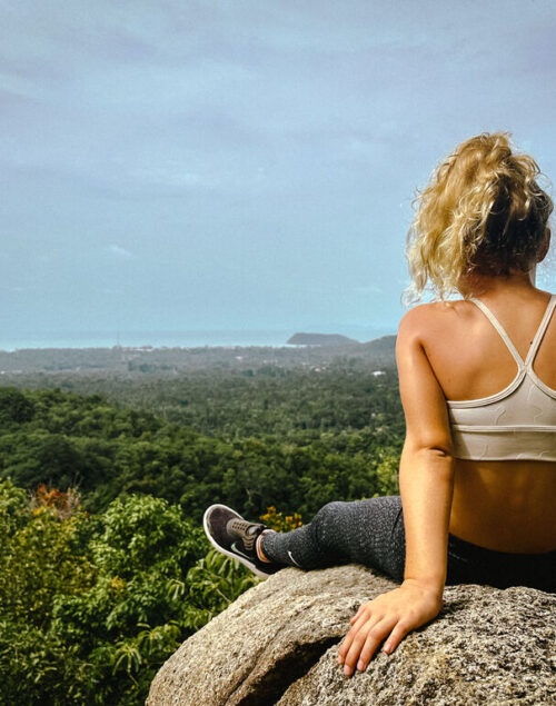 Girl sitting on a rock enjoying the views on the Phaeng Waterfall Hike in Koh Phangan