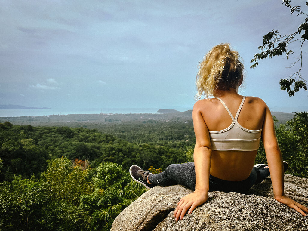 Girl sitting on a rock enjoying the views on the Phaeng Waterfall Hike in Koh Phangan