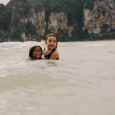 Two young girls playing in the sea. Krabi with Kids