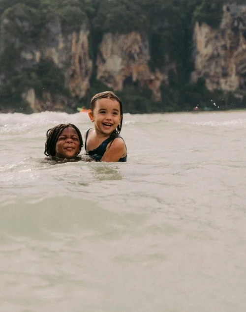 Two young girls playing in the sea. Krabi with Kids