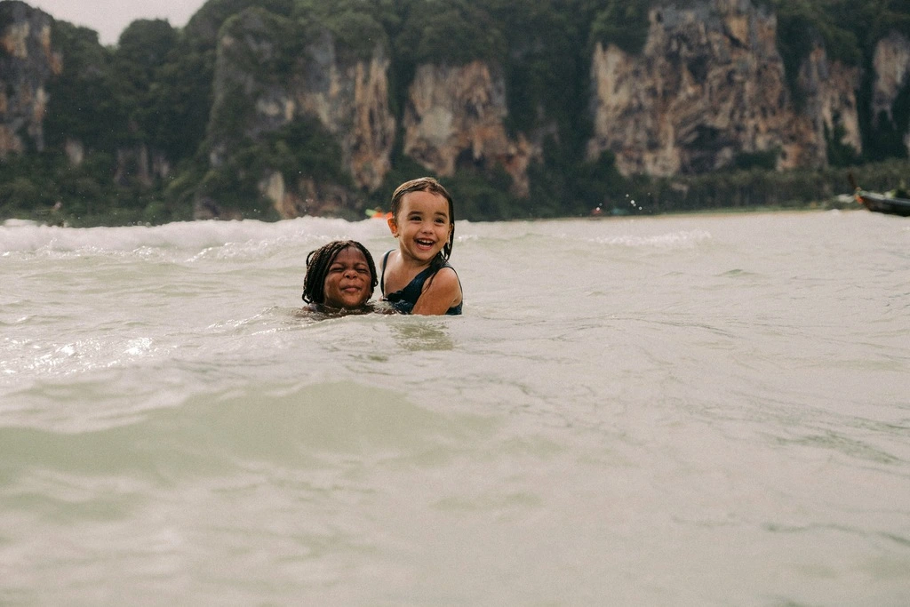 Two young girls playing in the sea. Krabi with Kids