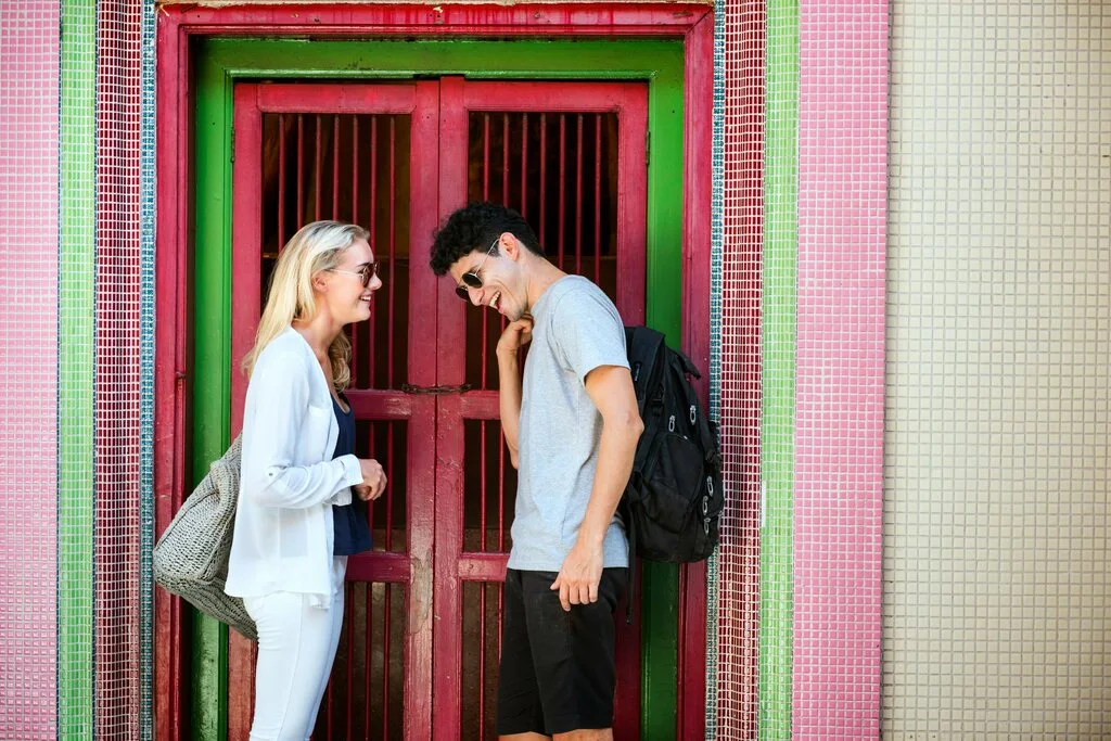 A young couple standing in front of a colorful door. What to wear in Thailand.