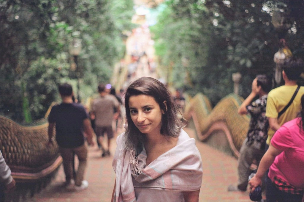 Woman with a scarf around her shoulder in a Thai temple.