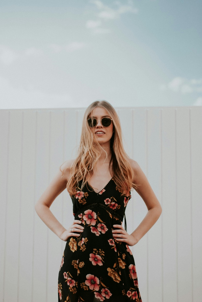 What to Wear in Thailand in 2026 – 20 Do's and Don'ts 34 Woman with sunglasses wearing a black dress with flowers.