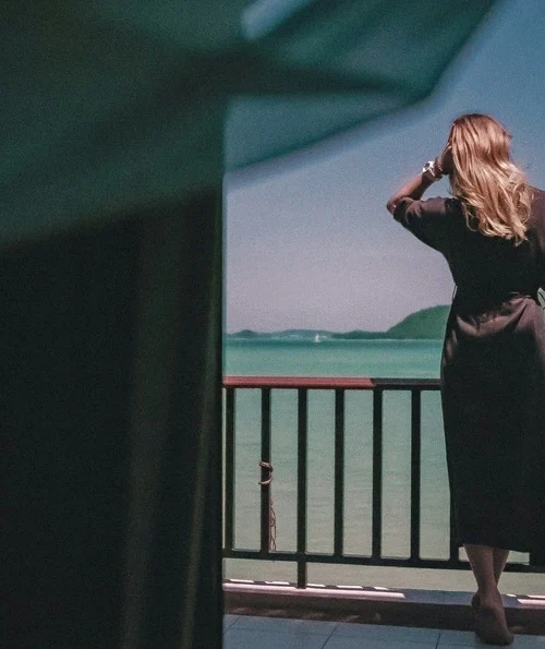 Women with black dress looking at the sea. What to wear in Thailand?