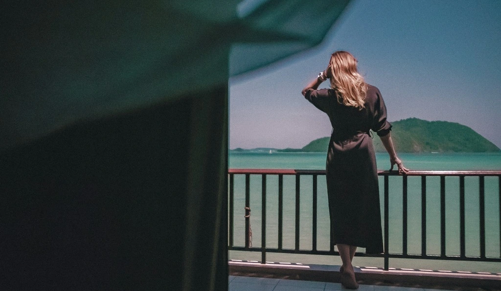 Women with black dress looking at the sea. What to wear in Thailand?