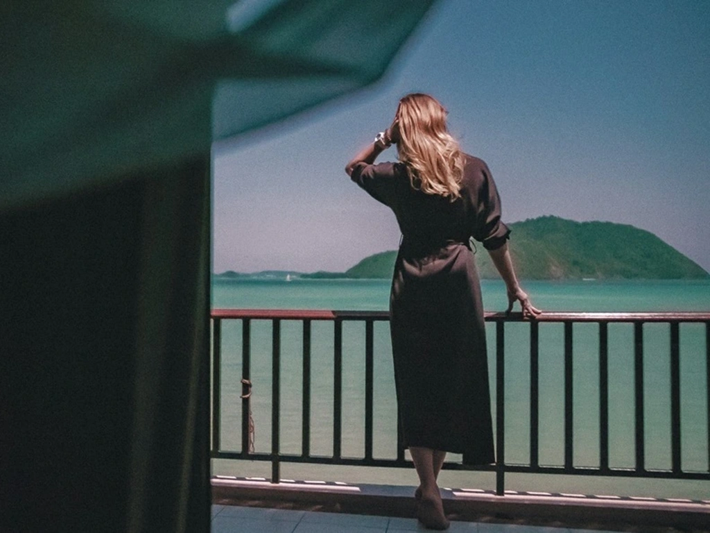 Women with black dress looking at the sea. What to wear in Thailand?