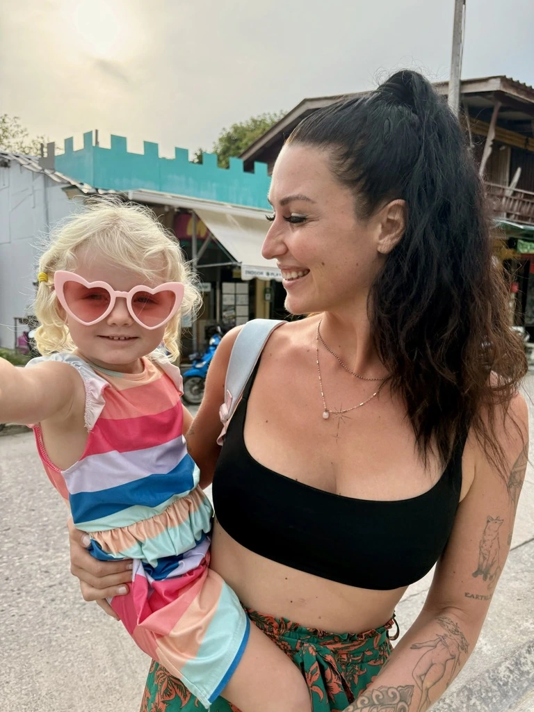 Mum and toddler daughter, wearing heart sun glasses. How to travel with a toddler