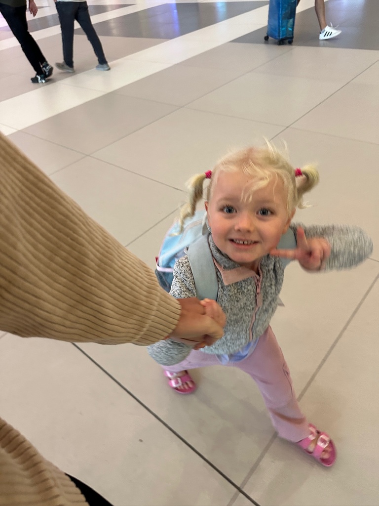Little girl with backpack walking on an airport.