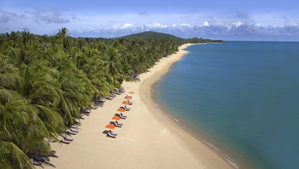 Tropical beach with lush green trees and a few sun beds, Koh Samui Luxury Hotels