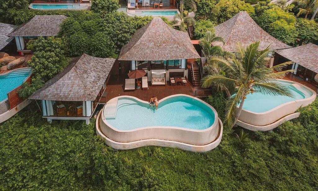 Birds view on private pool villas in lush greenery