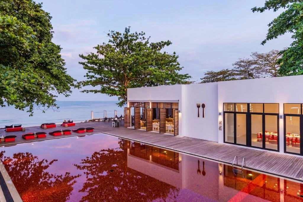 Red swimming pool and white hotel building next to it, koh samui luxury hotels