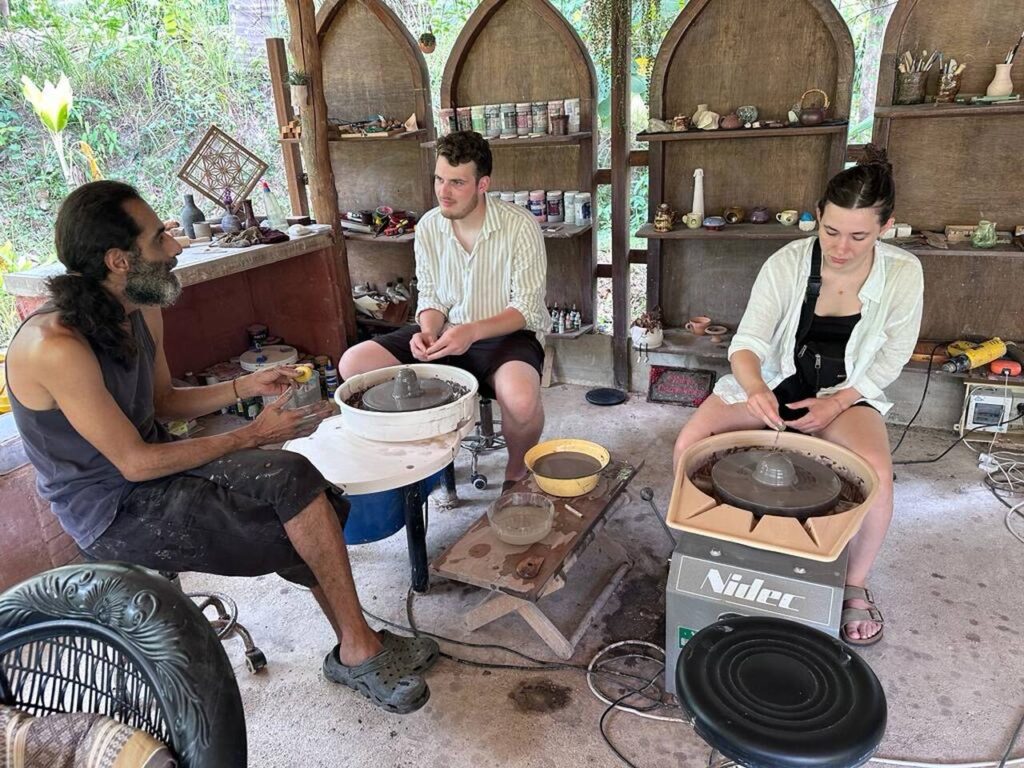 Three people working with pottery.