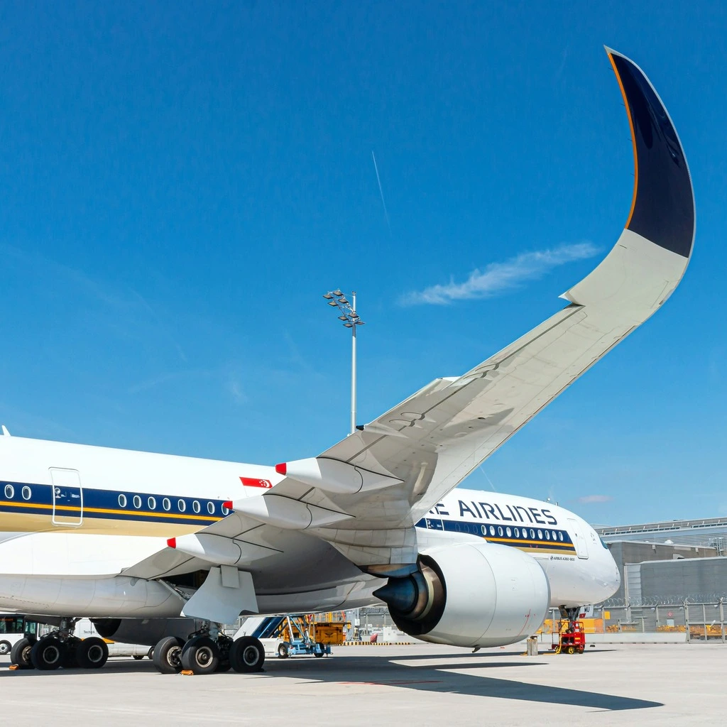 Airplane waiting at the airport, blue sky in the background.