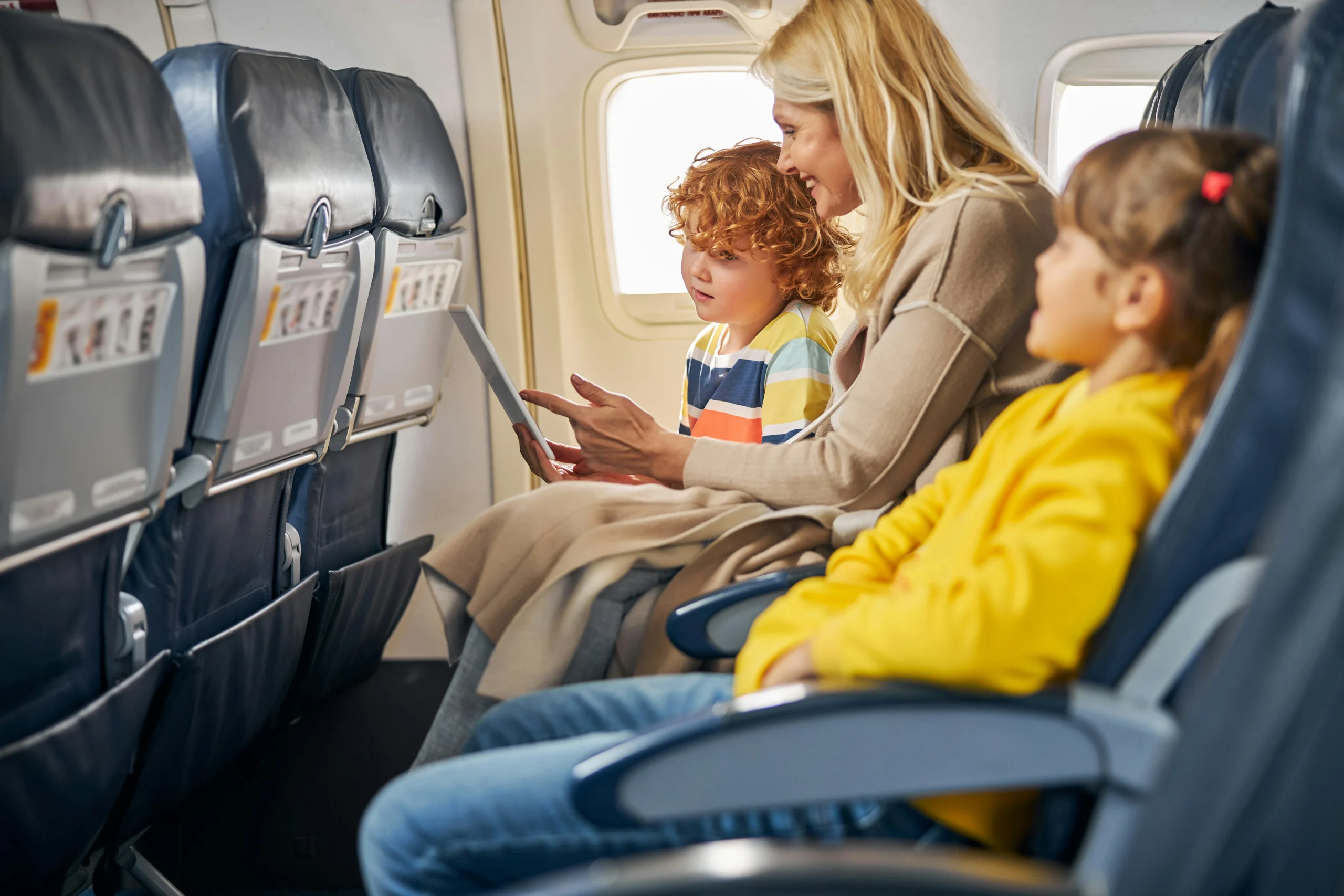 Mum with two young kids on a plane, How to Travel With a Toddler on a Plane.