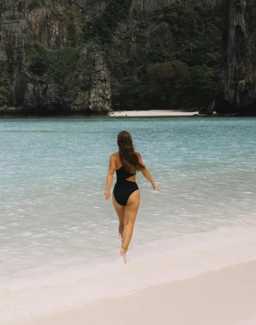 Woman walking on tropical beach, best time to travel to southeast asia