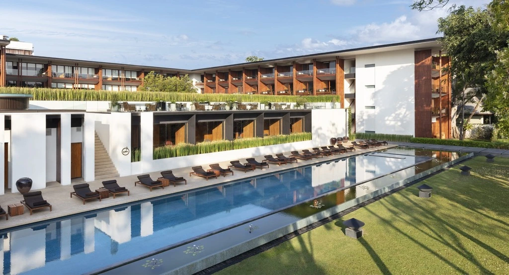 White Hotel building with wooden accents and a long lap pool