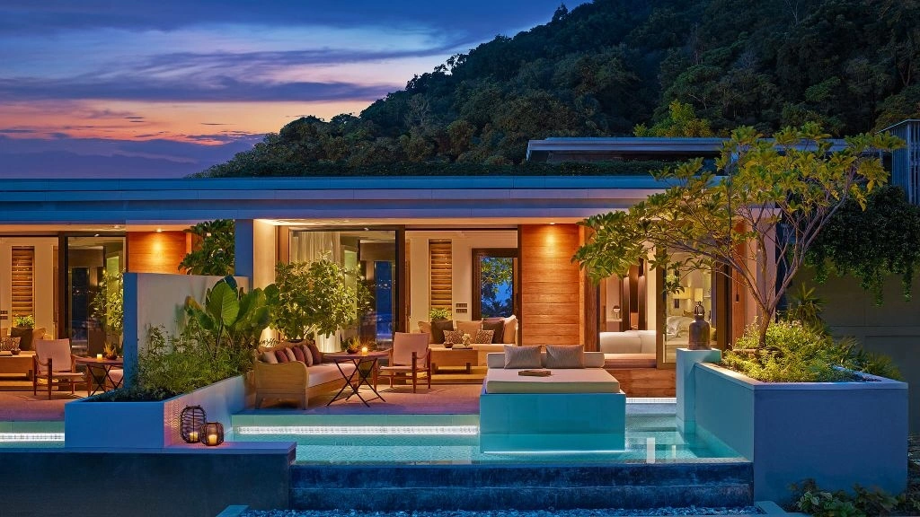 Private Villa with pool and wooden furniture by night