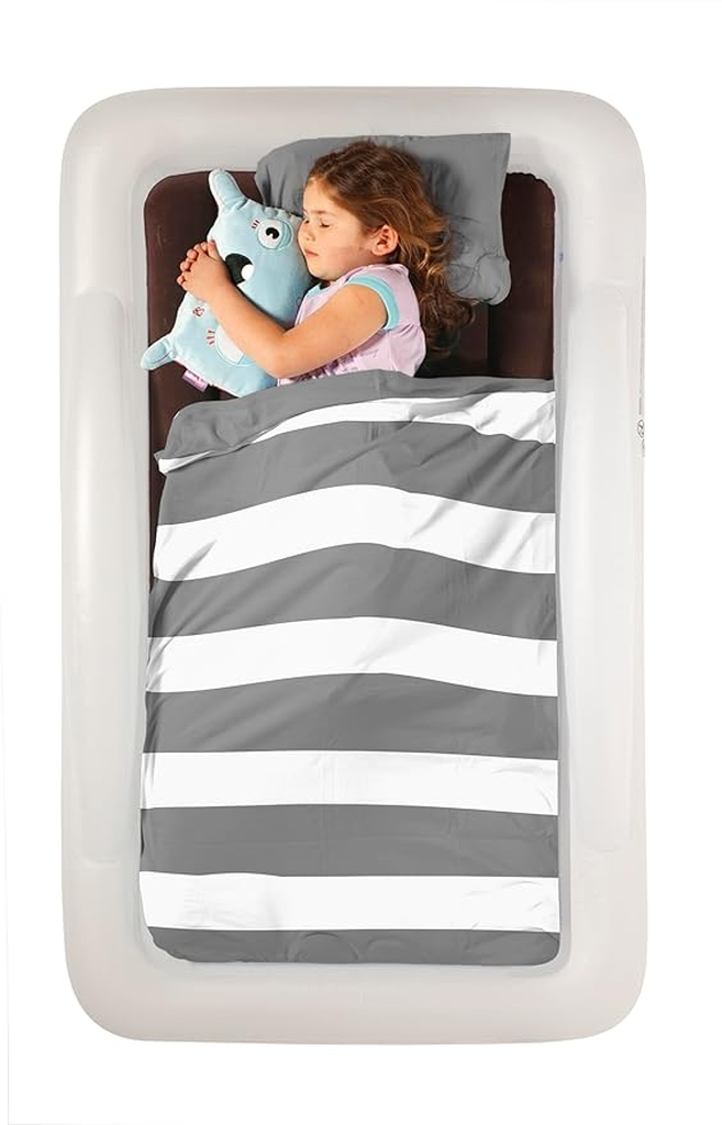 Little girl sleeping in an inflatable travel bed with grey and white blanket.