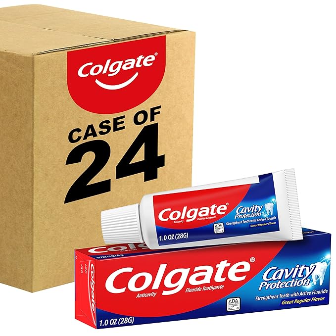 A pack of colgate toothpaste laying in front of a big box.