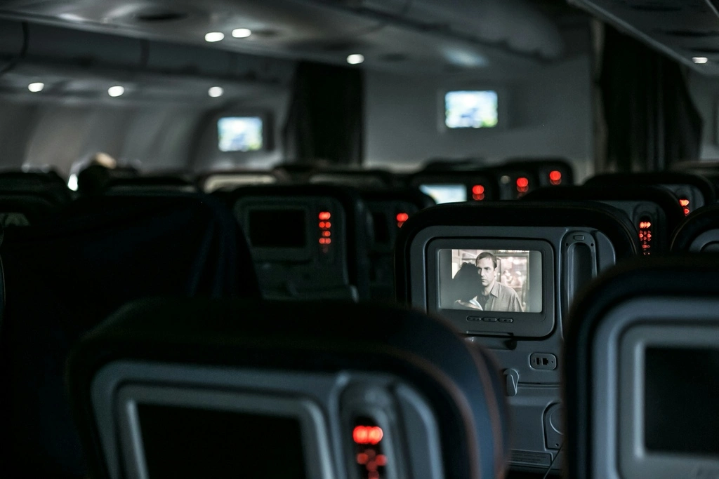 Plane aisle with empty seats, best movies to watch on a plane