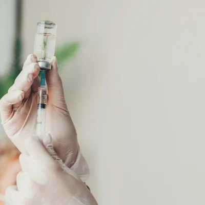 Hands holding a syringe, vaccines for Thailand travel