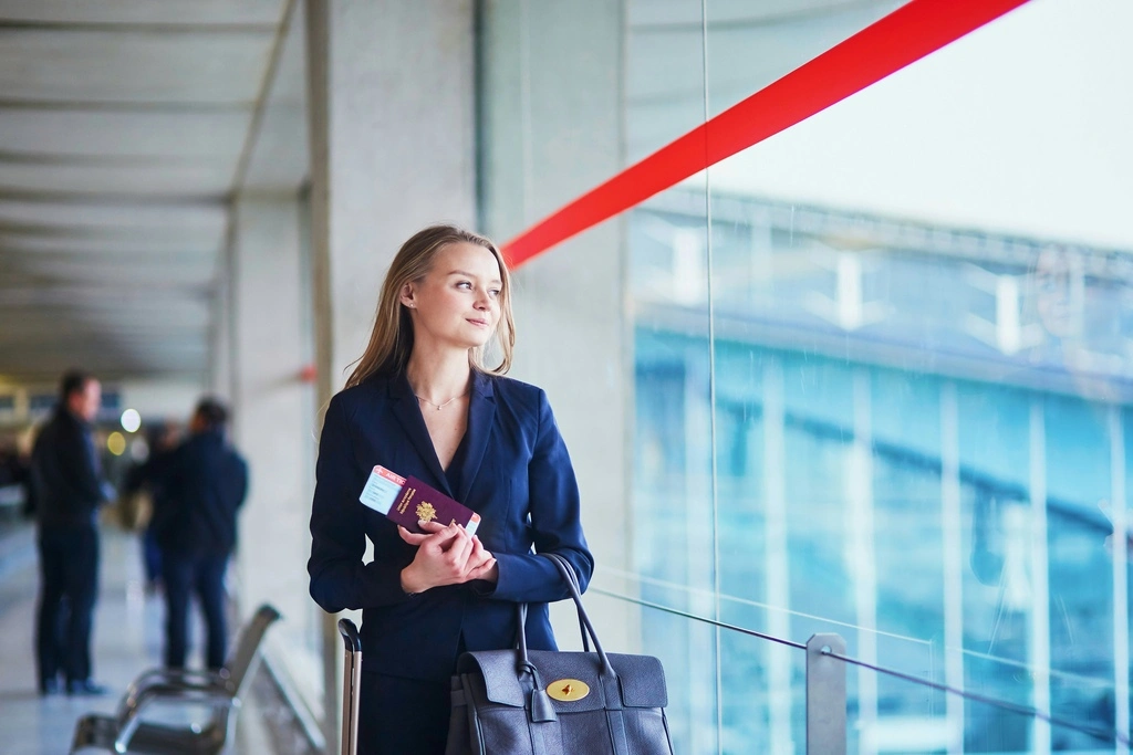 Woman holding a passport at the airport, what to bring on a plane