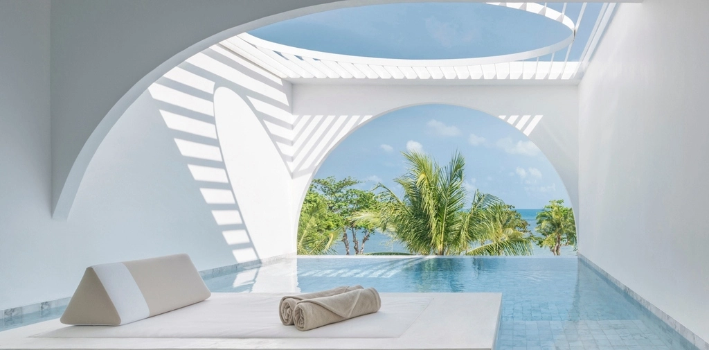 Pool terrasse with white walls and palm trees in the background. Best Honeymoon Resorts in Thailand