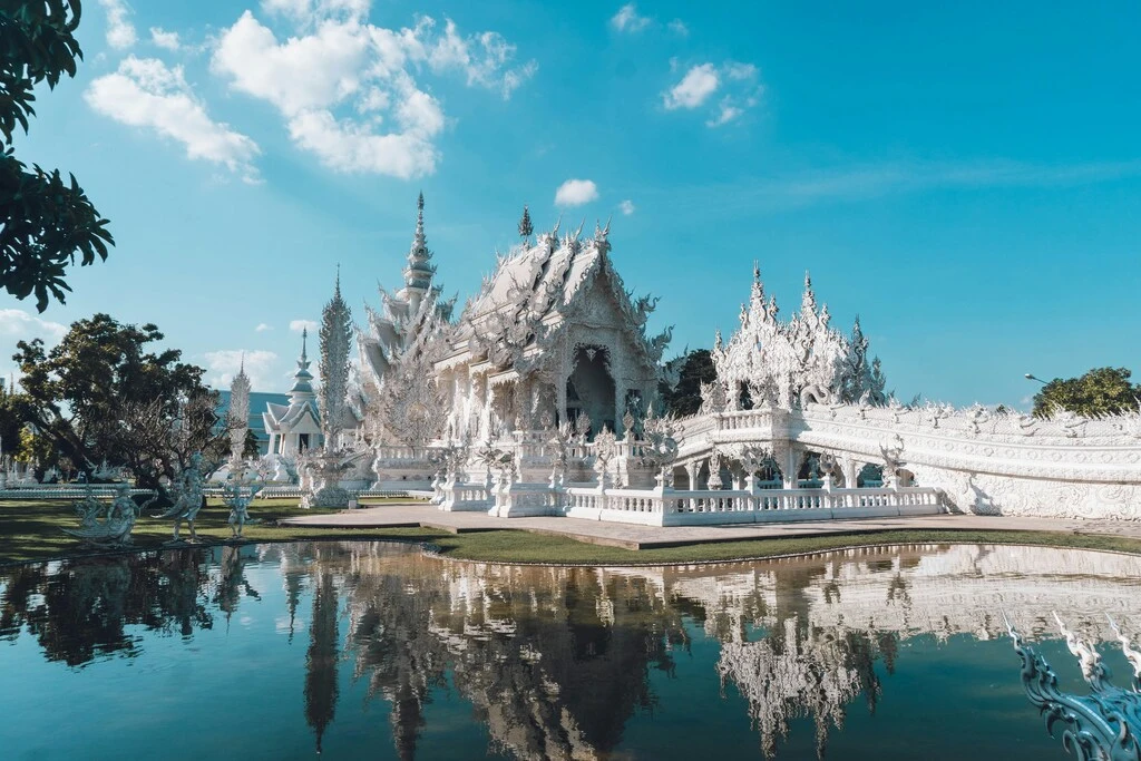 White temple complex with lake in the front. One of the most popular landmarks in Thailand.