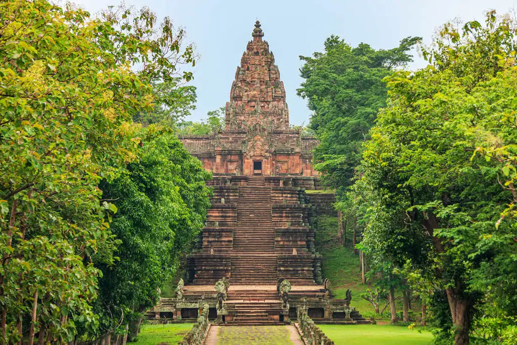 Stone temple at the end of an ancient stone stairs, surrounded by greenery.