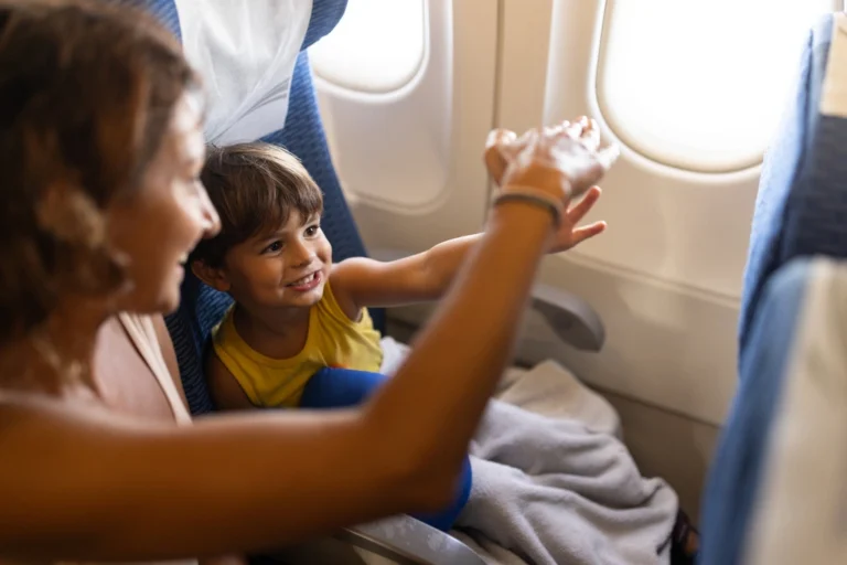 Mom playing with her toddler son in a plane, how to entertain a toddler on a plane.