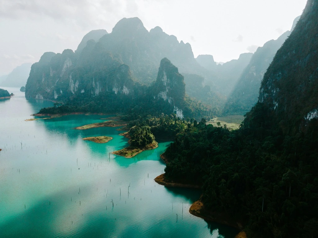 Turquoise water lake surrounded by cliffs and hills.